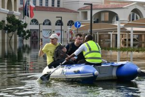A staff member transports guests on an inflatable boat to the entrance of a hotel engulfed in flood water in Dubai on April 22, 2024.